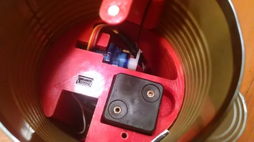 The talking can contains a small servo motor controlled by an Arduino Nano. Four AAA batteries provide the power supply, all held securely in a 3D printed housing. Can Internals Can Internals